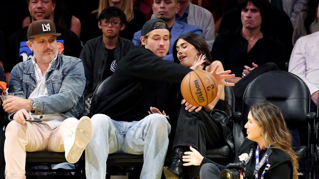 Chargers’ Justin Herbert protects Madison Beer from basketball at Lakers game
